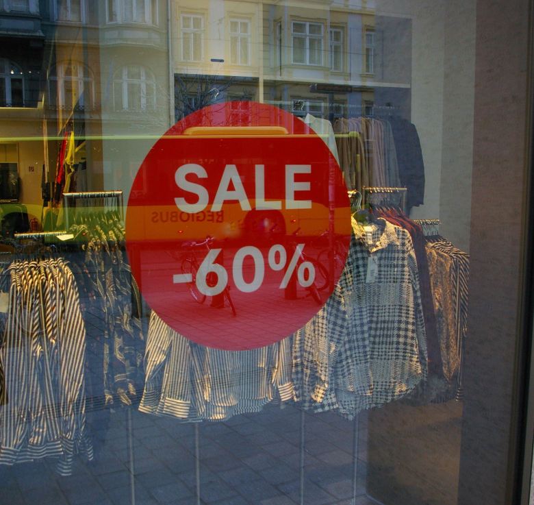 a picture of a storefront with a SALE sign serves as Low Buy inspiration
