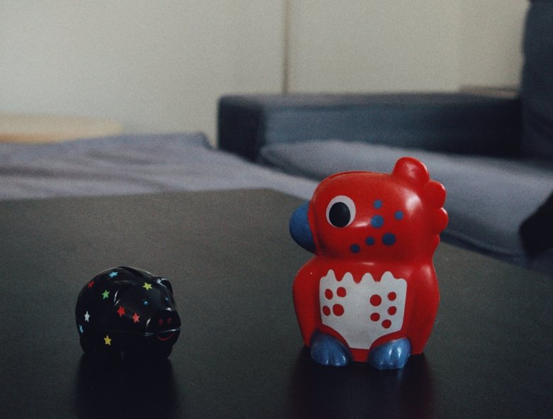 these two piggy banks in different designs on a table are really happy about this low buy may