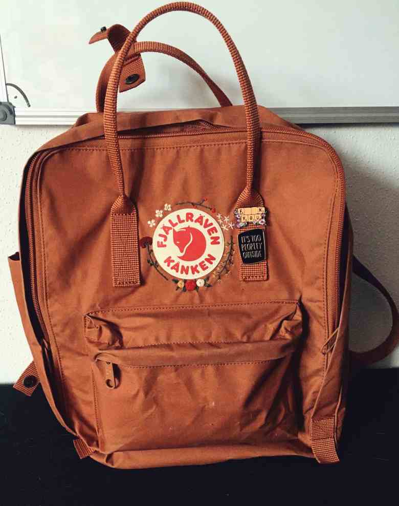 a fjällräven Kanken in color brick with embroidery and pins